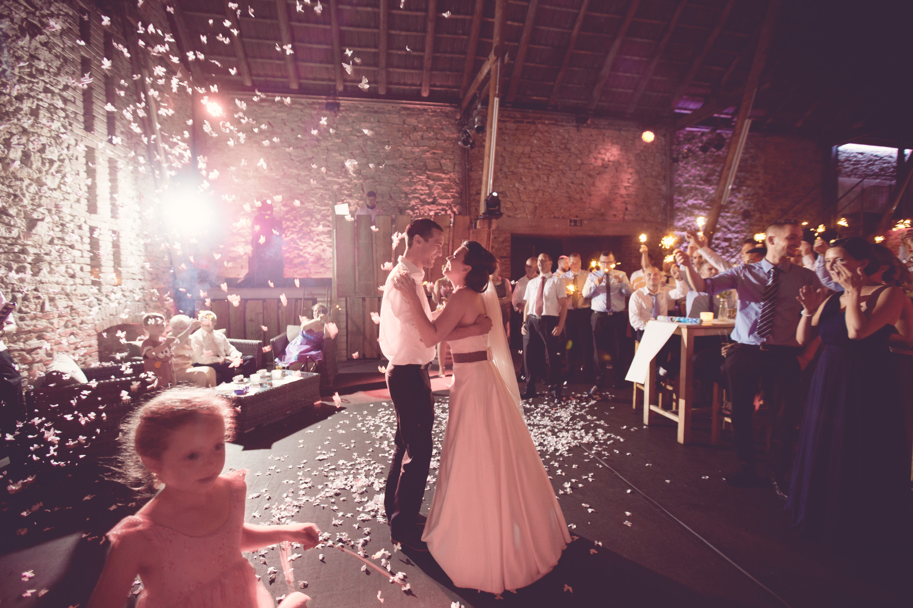 Hochzeitsfotograf Bielefeld – Brautpaar dreht sich beim Eröffnungstanz, Schmetterlings-Konfetti auf dem Boden, Kind im Vordergrund