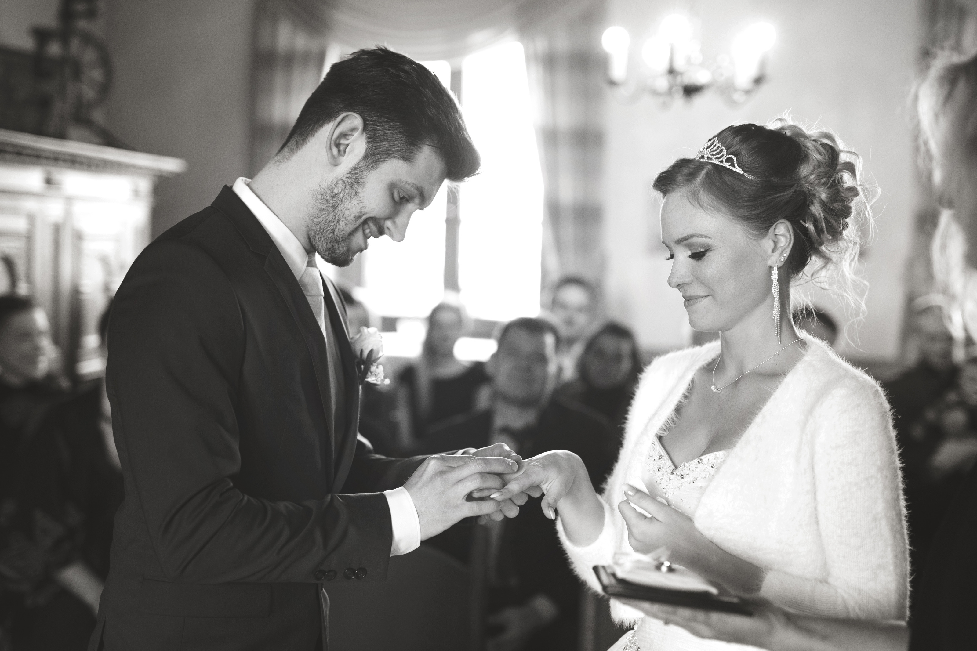 Hochzeitsfotograf Bielefeld – Schwarz-Weiß: Bräutigam steckt Braut den Ehering an beim Standesamt, beide schauen auf die Hände